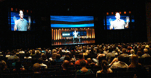 Example of a center screen dropped to the stage floor, utilizing a locked-down center camera shot from the main auditorium.