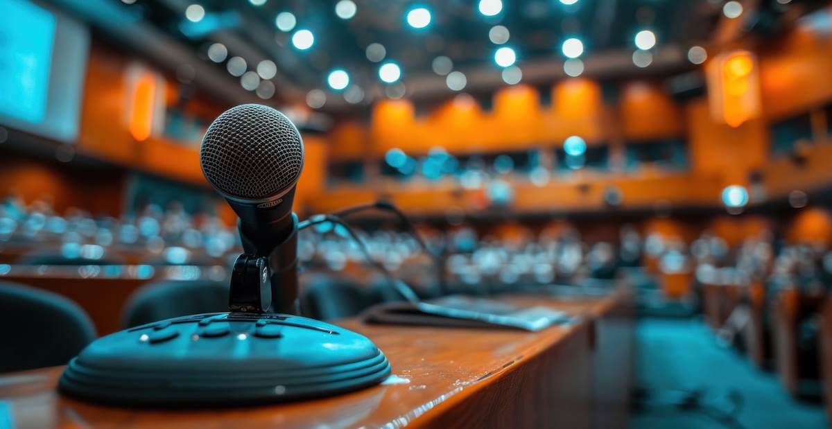 Education podium with a sound system and presentation remote in a large hall text